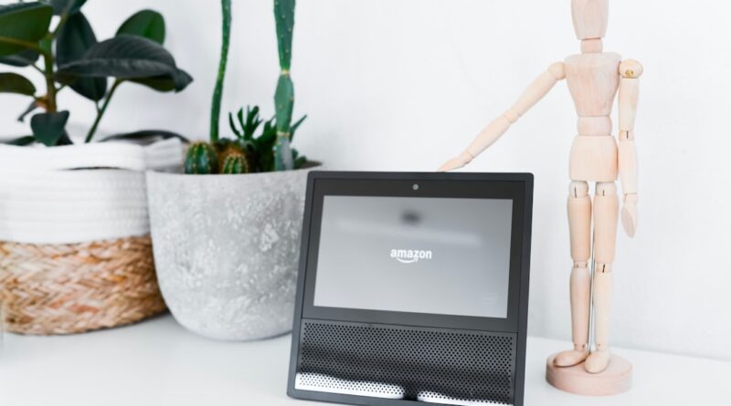 white mannequin miniature near Amazon tablet on table